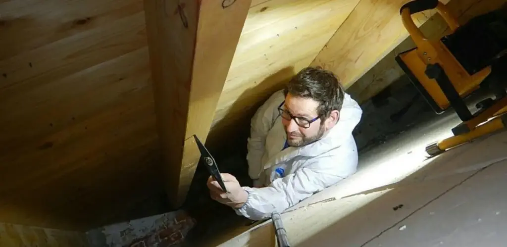 bouwkundig rapport en bouwtekening met meetlint en laserafstandsmeter op tafel in woonkamer