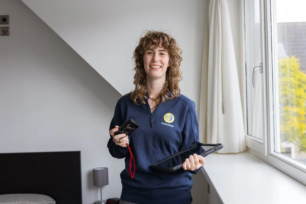 ep-adviseur controleert isolatie en radiator in Nederlandse rijtjeswoning met tablet