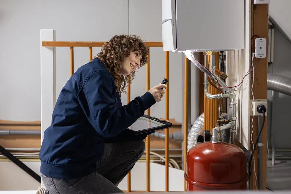 ep-adviseur met tablet inspecteert een lichte woonkamer voor het energielabel van een woning